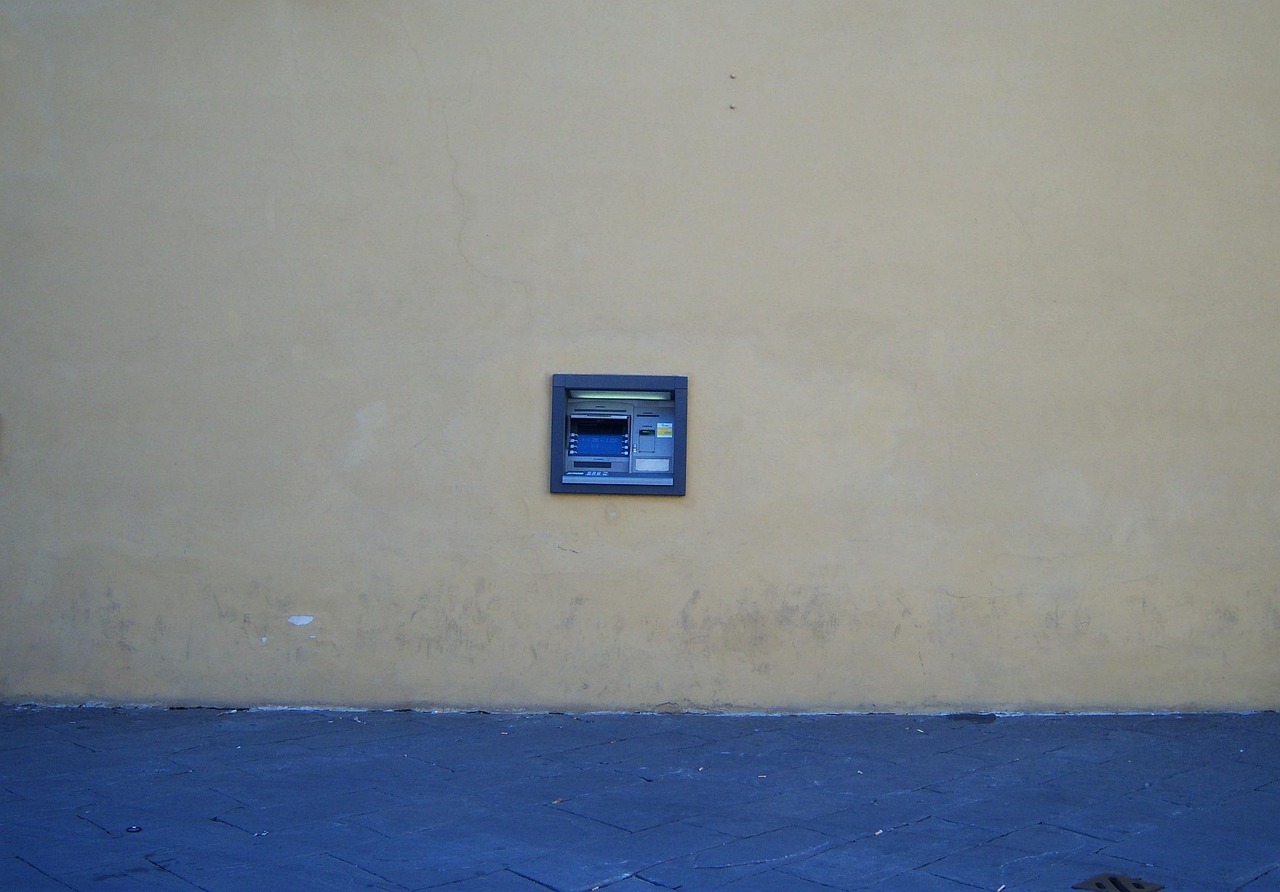 Immagine di un bancomat con avviso di allerta per restituzione contante prelevato.